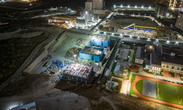 Verlichte bouwplaats bij nacht, gezien vanuit de lucht