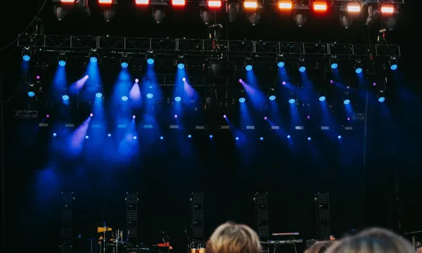 Festivalpodium met blauwe spots boven het publiek