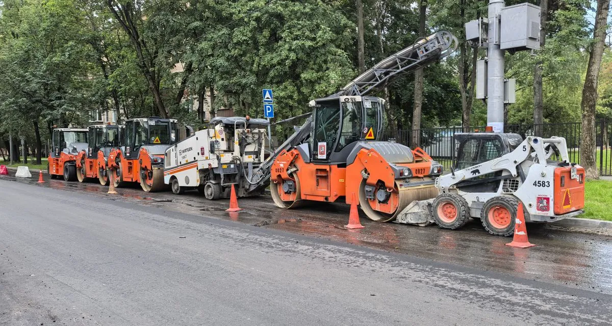Asfalteermachines en shovels op een rij langs een weg in aanleg